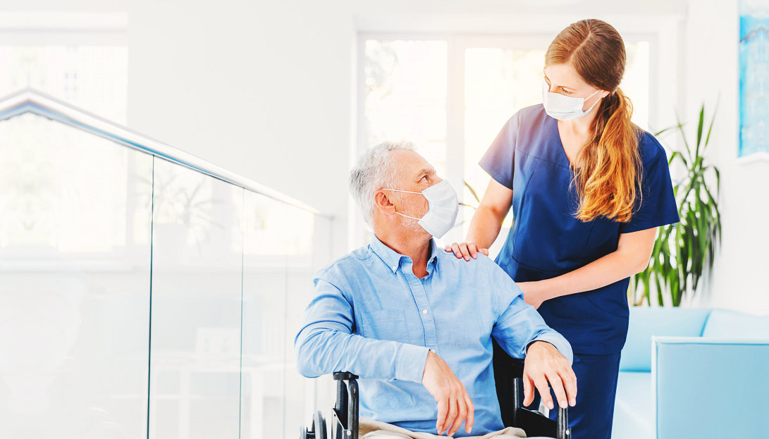 an elderly man with a caregiver woman